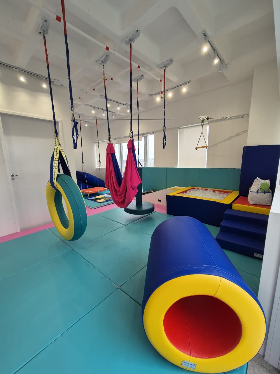 Sala ampla com diversos equipamentos de terapia