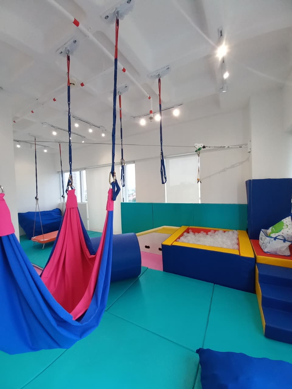 Área terapêutica com balanços e rede sensorial